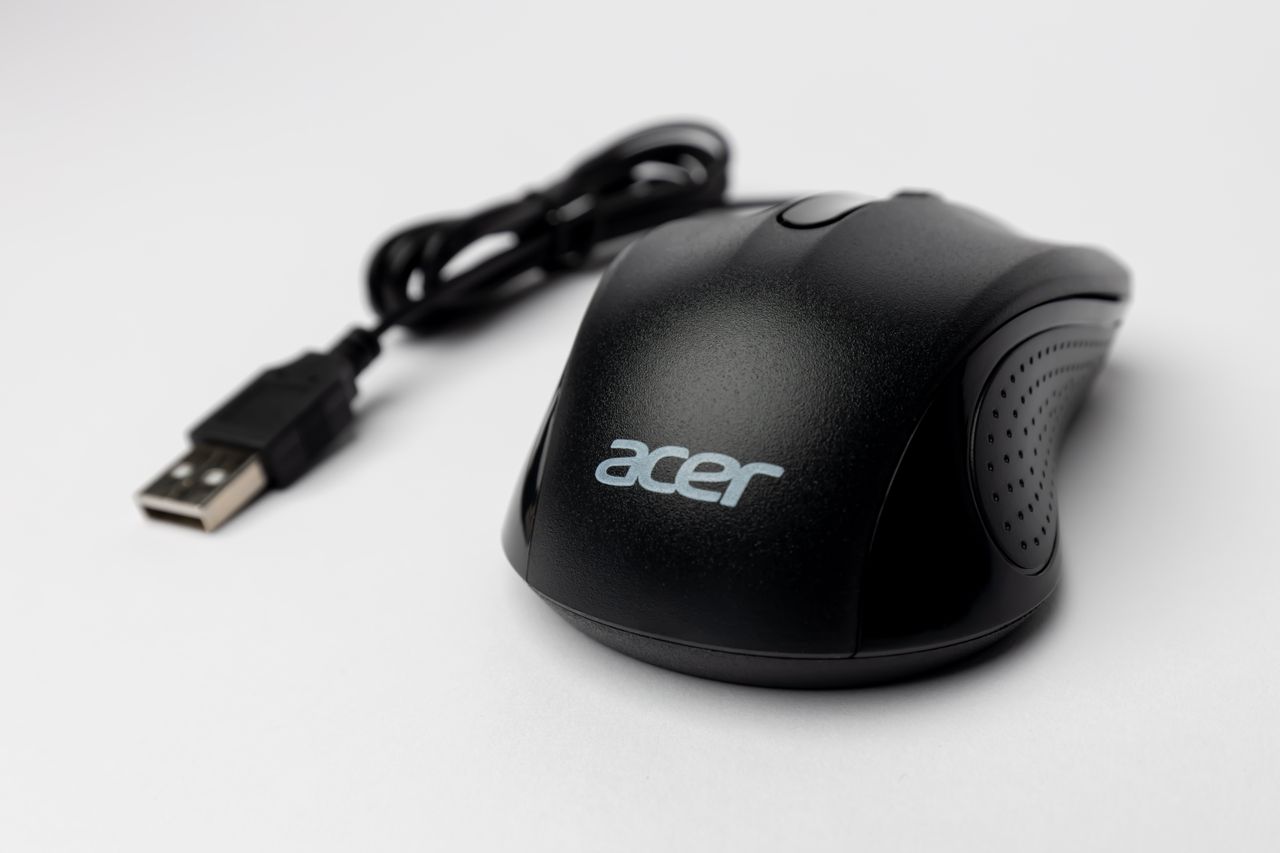 Close-up of a black computer mouse with USB cable on a white background.